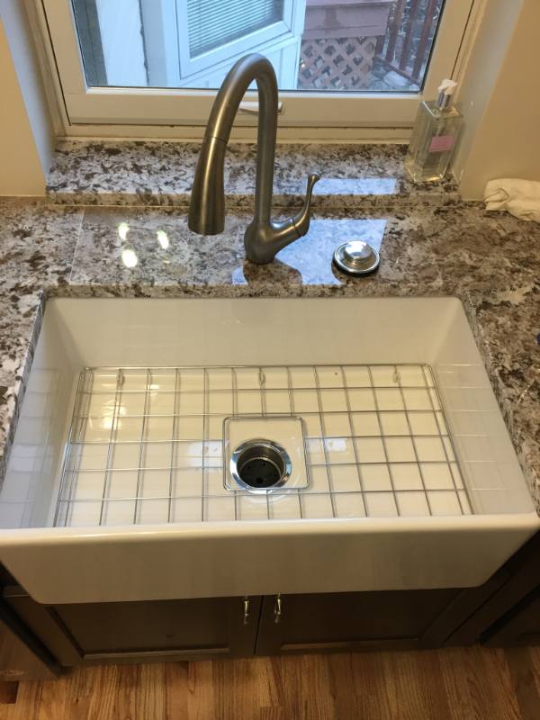 Farmhouse kitchen sink with a bronze pull-down faucet